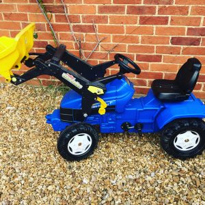 blue and yellow New Holland tractor with front scoop