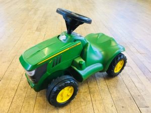 small green John Deere ride on toy tractor